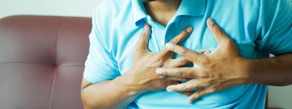 man in blue shirt holding his chest